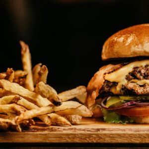 Mouthwatering cheeseburger and crispy fries on a wooden board, perfectly capturing fast food appeal.